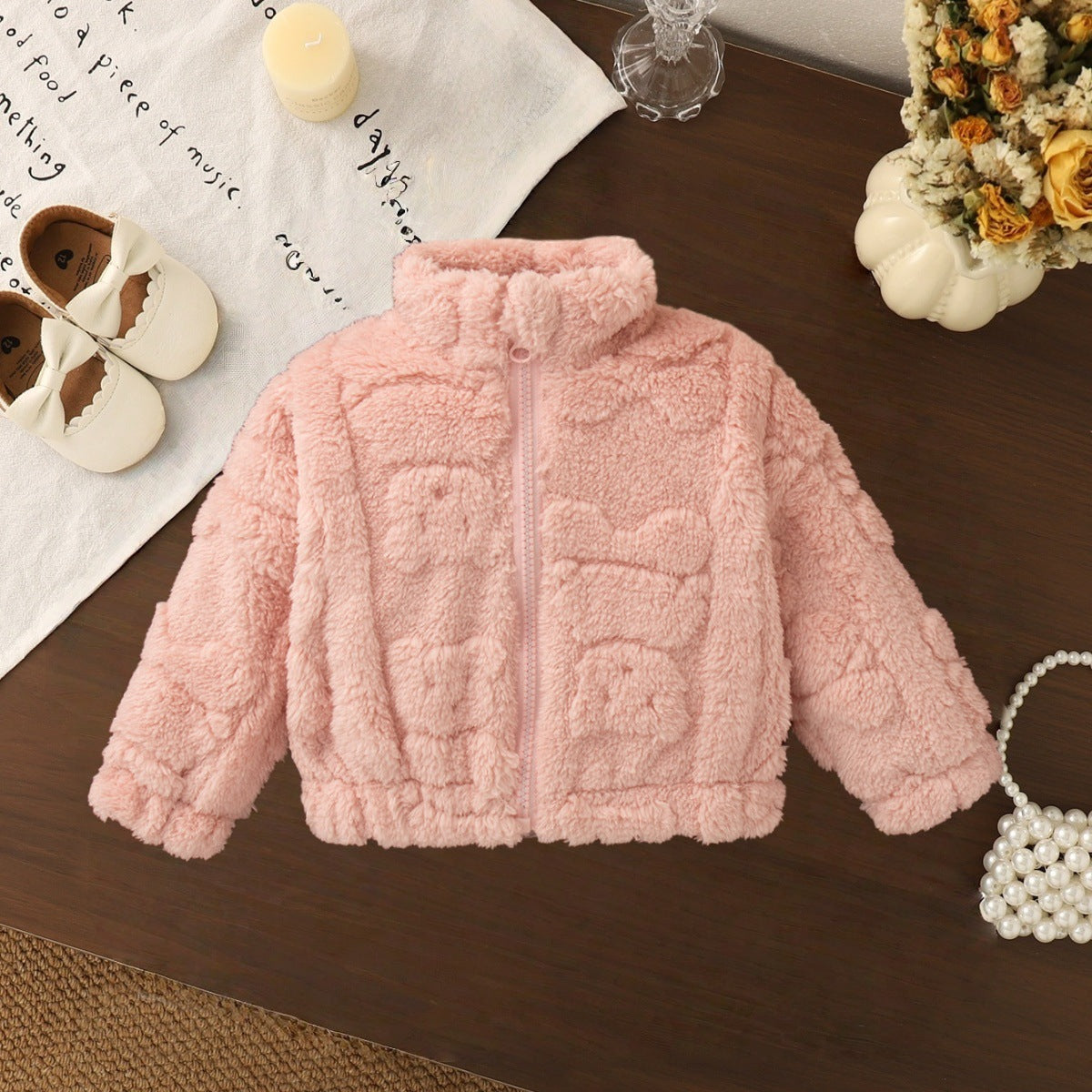 ピンクの無地フリースジャケットを平置きにした女の子用アウターの写真