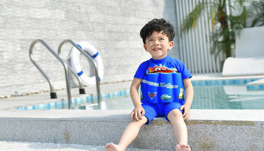 プールサイドに座る男の子の浮力付きワンピース水着 カートゥーンプリントが見えるシーン