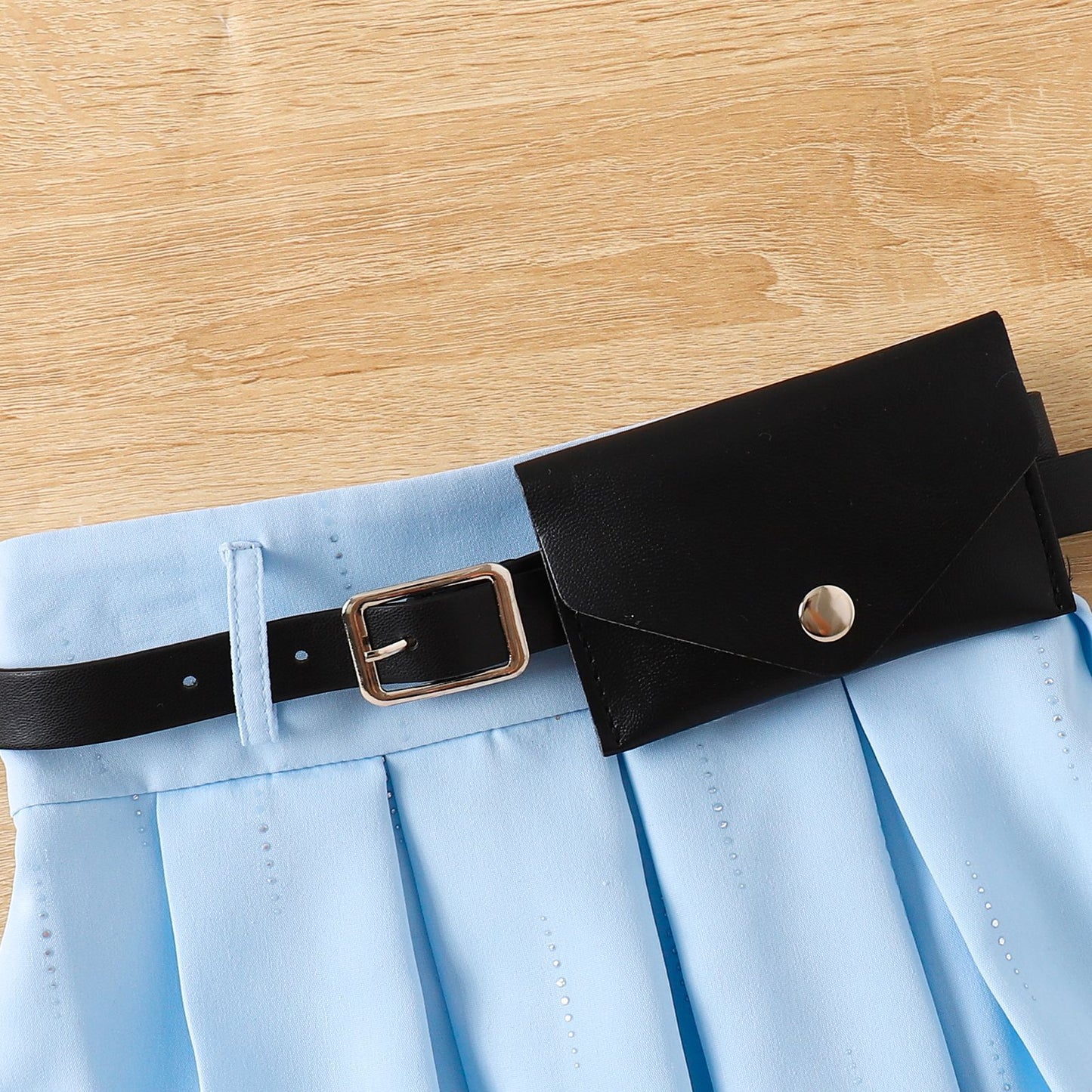 ウエスト部分のベルトとプリーツスカートのデザインが分かるクローズアップ