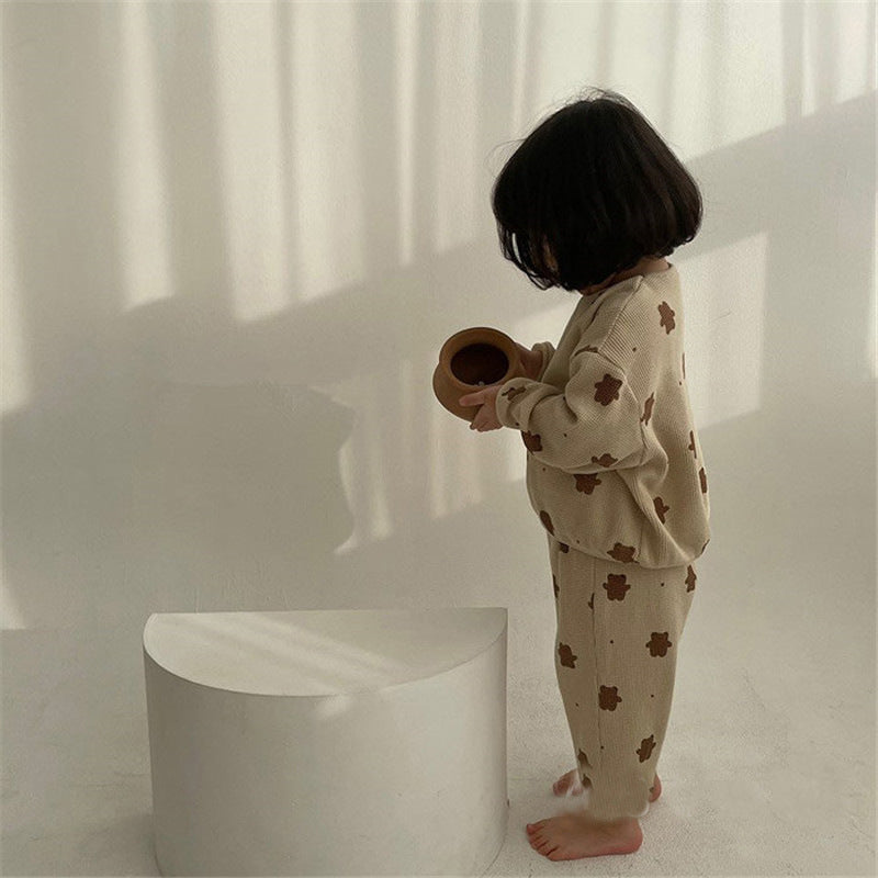 くま柄長袖スウェットとロングパンツを着た子どもが横向きで歩いているシルエット