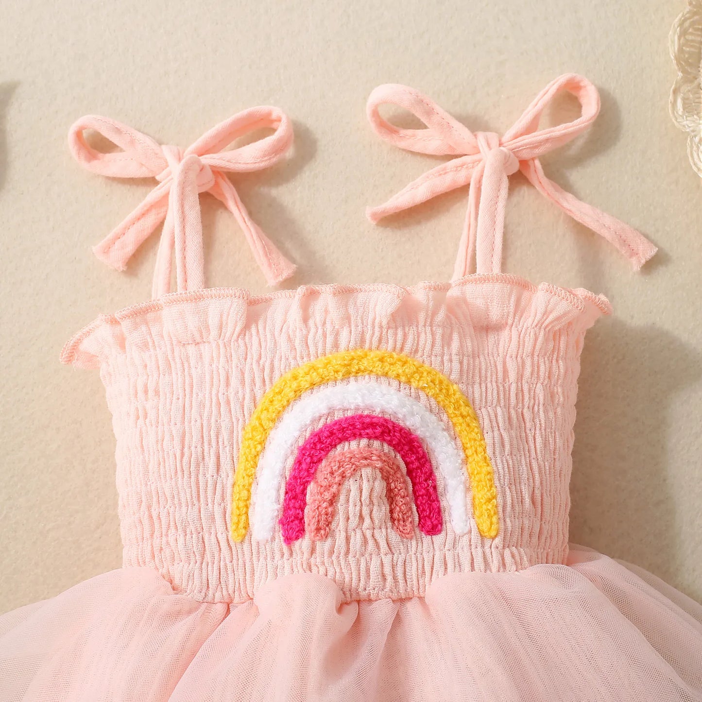 ピンクのレインボー刺繍と肩リボンのアップディテール