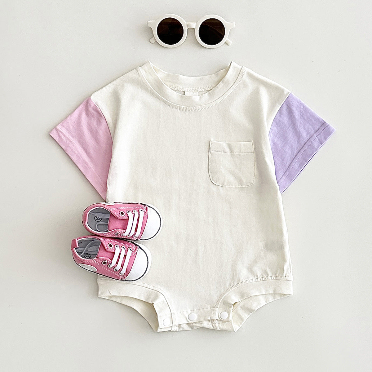 パープル配色の半袖ボディスーツのフラットレイ