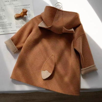 ミドル丈シルエットとシングルボタンが見えるガールズコートの前面写真
