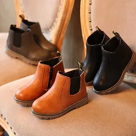 椅子の上に並んだ黒色の子どもレザーショートブーツ
