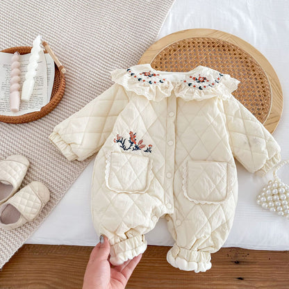 裾まわりとポケット刺繍を手で持ち上げた厚手キルティングベビーカバーオールのディテールショット
