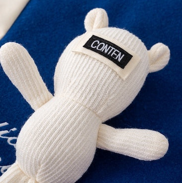 ニット素材のくまモチーフとロゴタグのディテールが分かる胸元アップ画像
