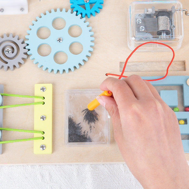 ペン型パーツで鉄粉模様を動かして遊ぶビジーボードのクローズアップ写真
