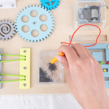 ペン型パーツで鉄粉模様を動かして遊ぶビジーボードのクローズアップ写真
