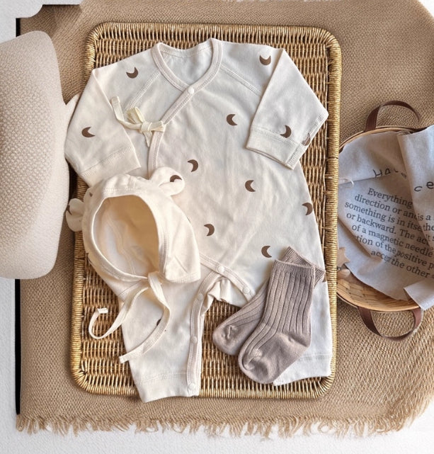 袖口と足元まで写った長袖ムーン柄ベビーカバーオールの全体画像
