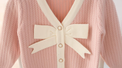 ピンクカラーのリボン付きベビーセーター
