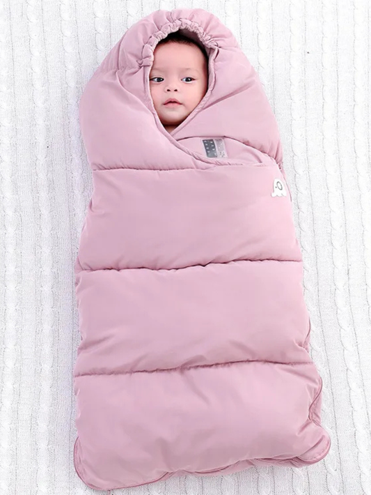 ピンクのベビー寝袋スリーピングバッグにすっぽり包まれて仰向けに寝ている赤ちゃんの全身写真（ベビー寝袋 ピンク 防寒）
