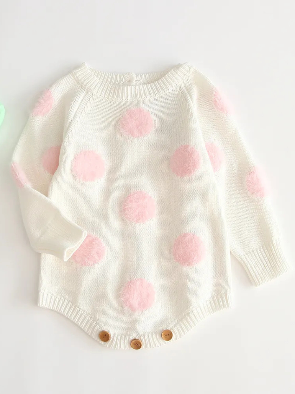 ホワイト地にピンクドットが並ぶニットベビーボディスーツ正面
