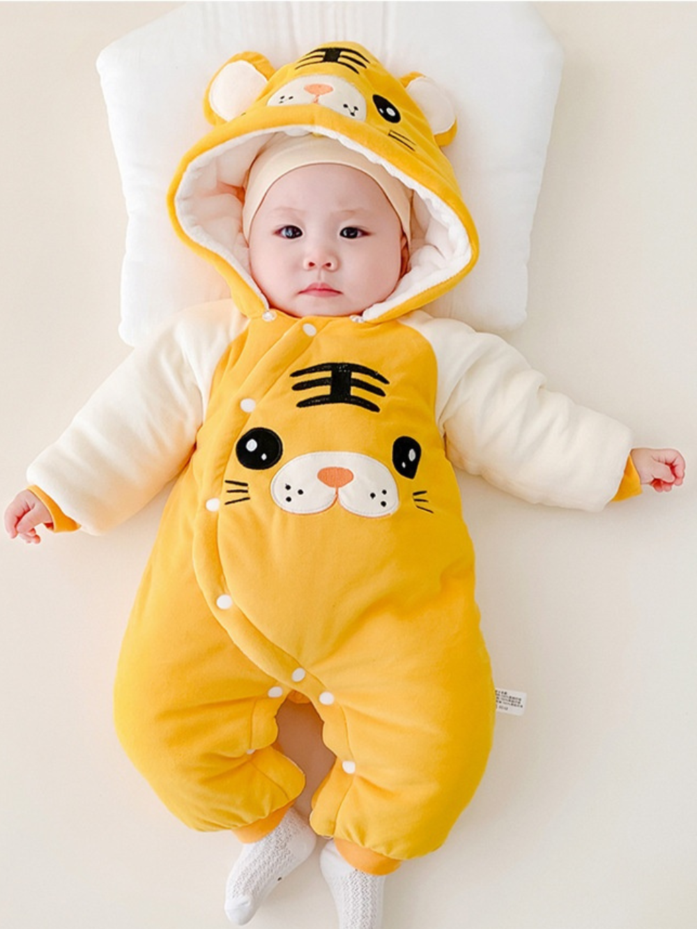 イエロータイガー着ぐるみ風厚手カバーオールを着て仰向けに寝ている赤ちゃんの全身ショット
