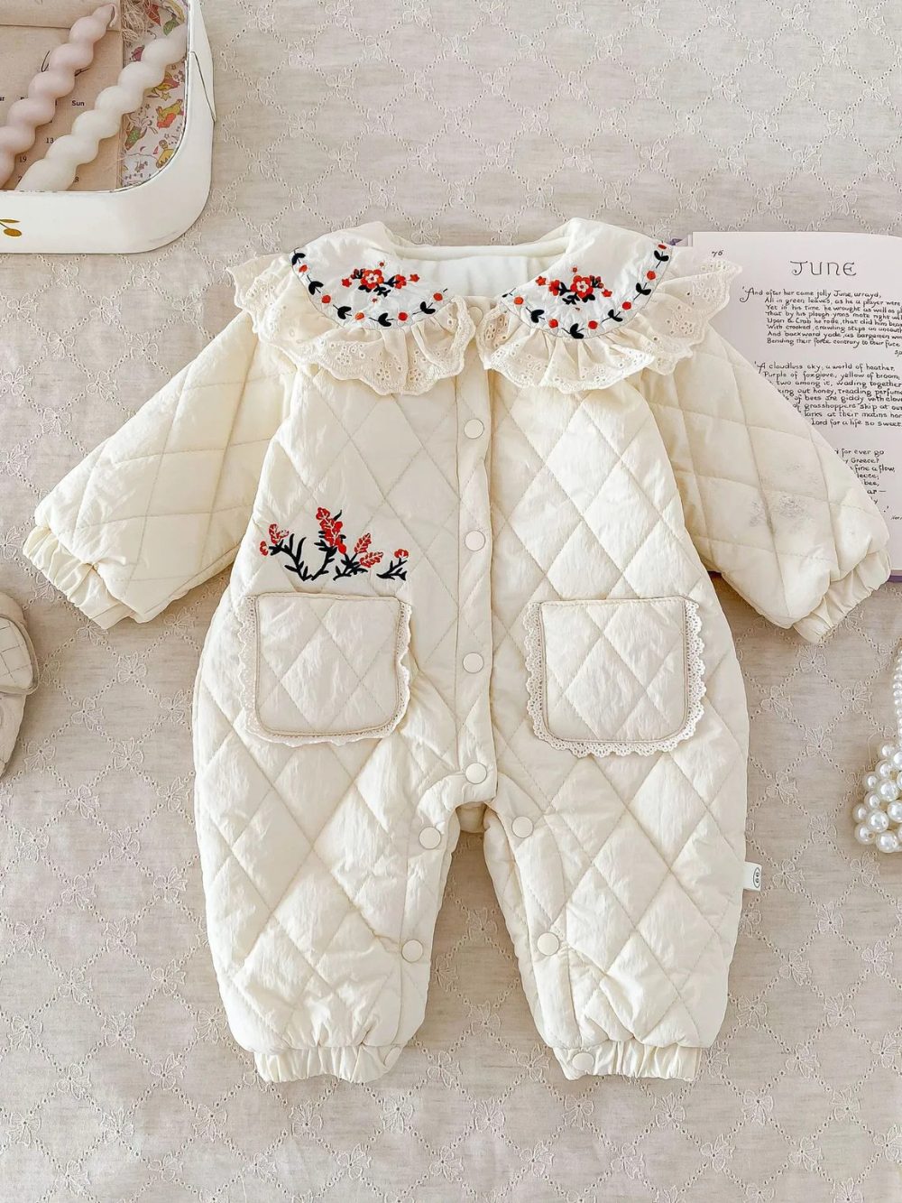 小花柄フリル襟とキルティング生地が特徴のアプリコットカラー厚手ベビーカバーオール前面デザイン
