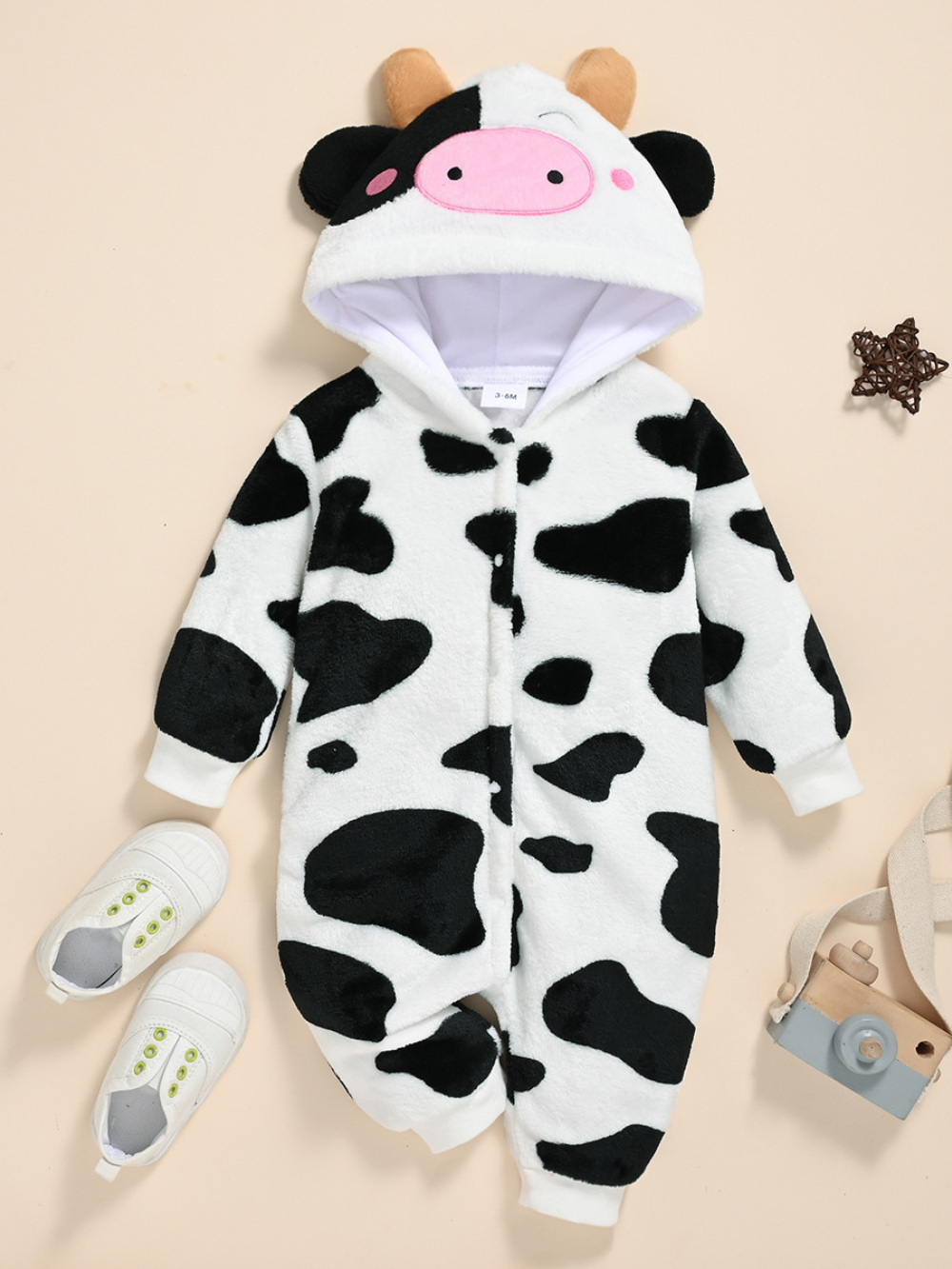牛の顔付きフードとモーモー柄が全面に入ったフード付き長袖ベビーカバーオール正面ショット
