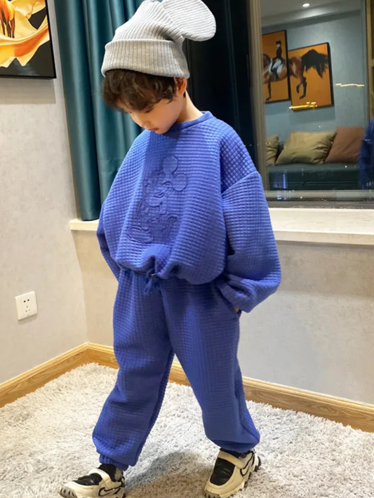 ブルー長袖トップスとパンツのセットアップを着た男の子が横向きで歩いているシルエット
