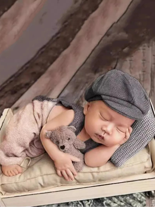 グレーのニット風オーバーオールとキャップを着た新生児男の子の写真撮影用コスチューム
