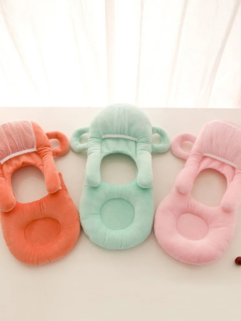 オレンジ・グリーン・ピンクの3色ベビー授乳クッションが横一列に並んだライフスタイル写真 (授乳クッション ベビー カラー展開)

