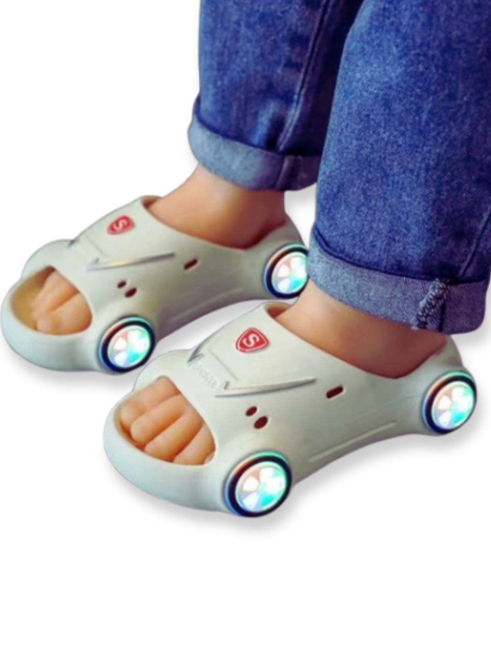 車輪が光るベージュのキッズスポーツカーサンダルを履いた子どもの足元クローズアップ
