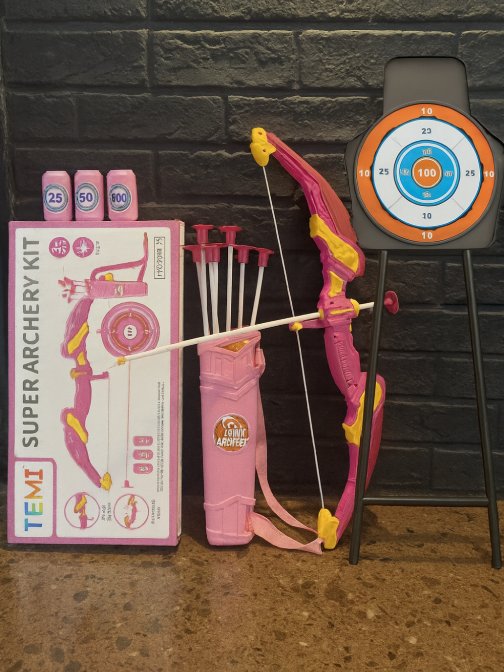 ピンク色ライト弓1本と吸盤矢10本、矢筒1本、大型スタンド付き的ターゲット1個、缶的3個がフル装備でレイアウトされた豪華セットの画像

