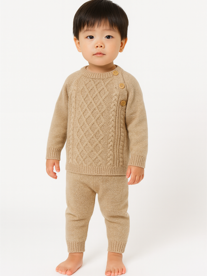 キャメルカラーのベビーニットセットアップを着て立っている子どもの全身コーデ
