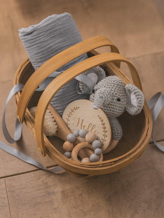 バスケットに入ったベビーギフトセット（ガーゼブランケット、木製トイ、クロシェぬいぐるみ）
