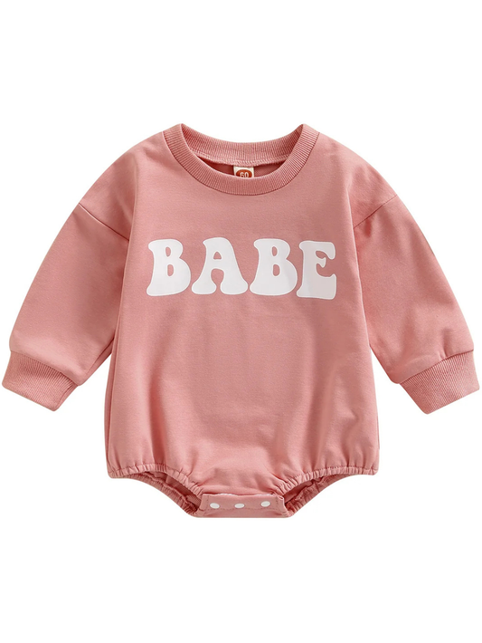 ピンクの長袖ベビーロンパース コットンニット素材の「BABE」ロゴデザイン
