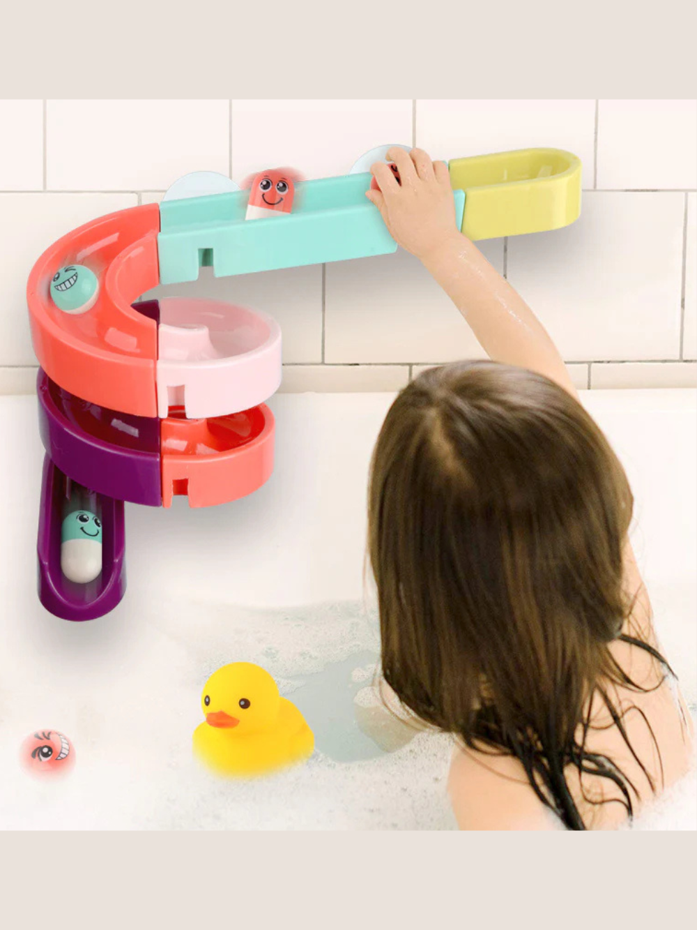 浴室の壁に吸盤で固定したウォータートラックで遊ぶ子どもの後ろ姿 水路コースとアヒルのおもちゃが見える使用イメージ
