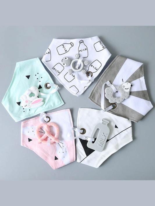 黄色い背景に置かれたミルク柄スタイと食品グレードシリコン歯固め
