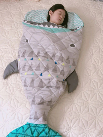 サメモチーフのグリーン系キッズ寝袋を床に広げたトップビュー（サメ キャラクター寝袋）
