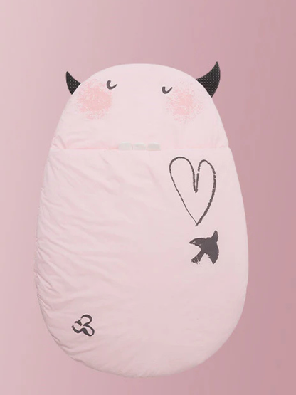 ライトピンクの卵型スリーピングバッグをソファの上に置いた商品写真（ライトピンク 卵型ベビー寝袋）
