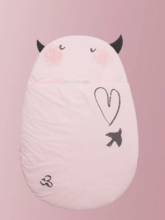 ライトピンクの卵型スリーピングバッグをソファの上に置いた商品写真（ライトピンク 卵型ベビー寝袋）
