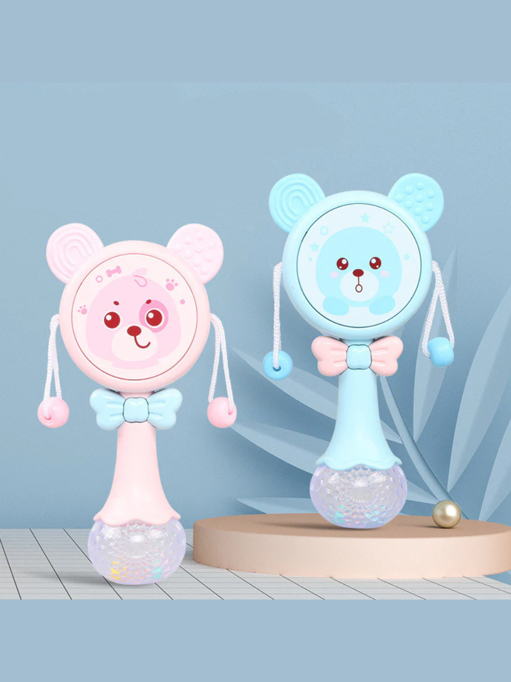 赤ちゃんのそばに置かれたベビーミュージックラトルと柔らかいブランケット
