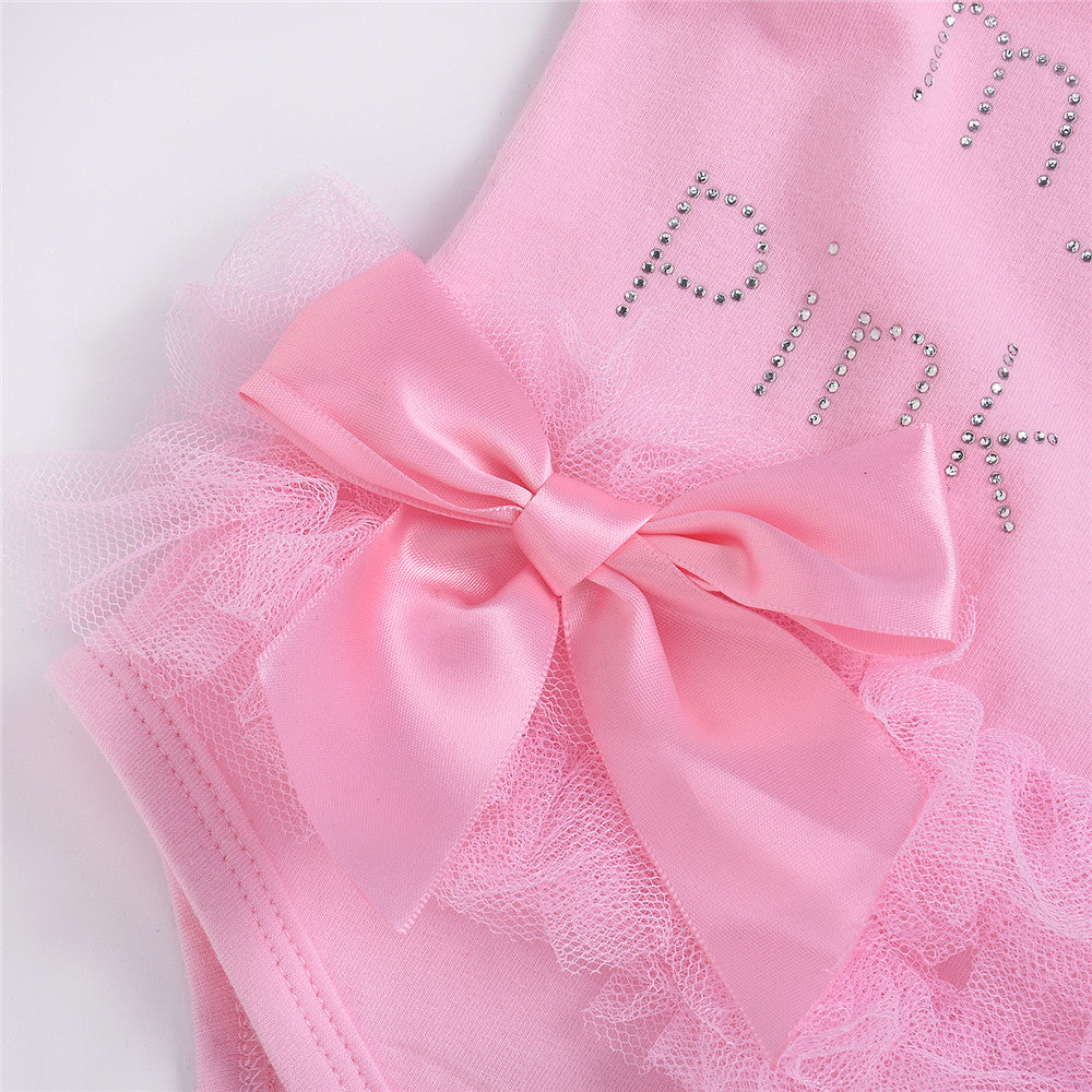 ピンクのリボンとチュールフリルの質感が分かるベビーボディースーツのアップ
