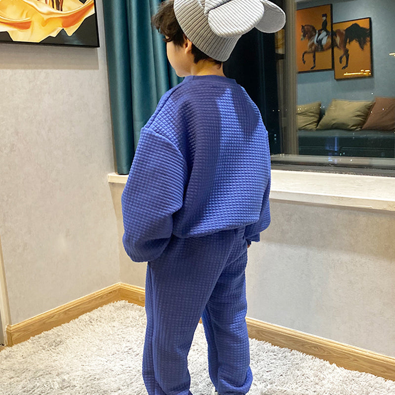 ブルー無地セットアップ姿の男の子を後ろから写したバックスタイル全身
