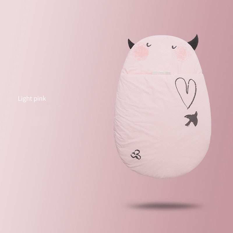 ライトピンクの卵型スリーピングバッグをソファの上に置いた商品写真（ライトピンク 卵型ベビー寝袋）
