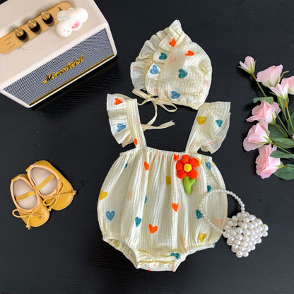 帽子付きのハート柄ベビーロンパースを小物と並べたセットイメージ
