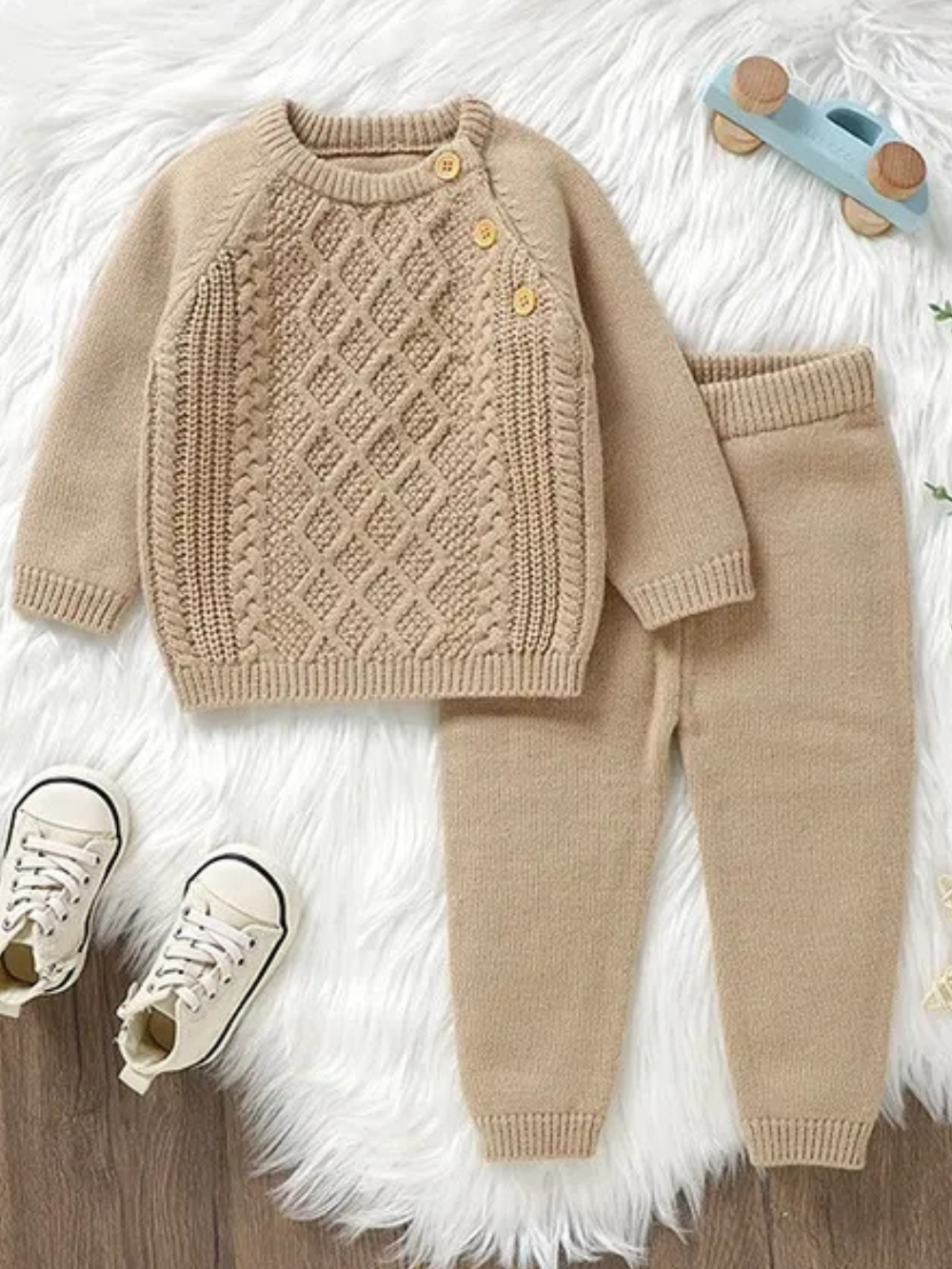 キャメルカラーのベビーニットトップスとフルレングスパンツ上下セットのフラットレイ
