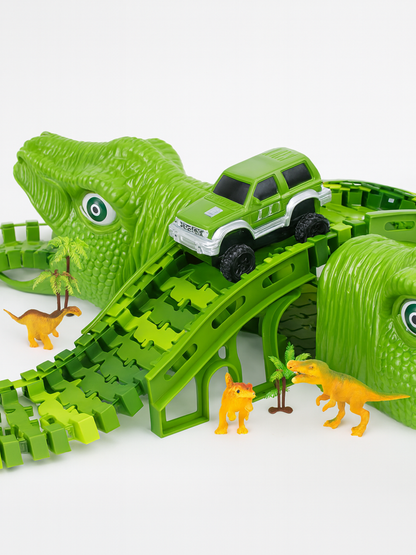 巨大な緑色の恐竜トラックと電動オフロードカーで遊ぶ男の子の写真
