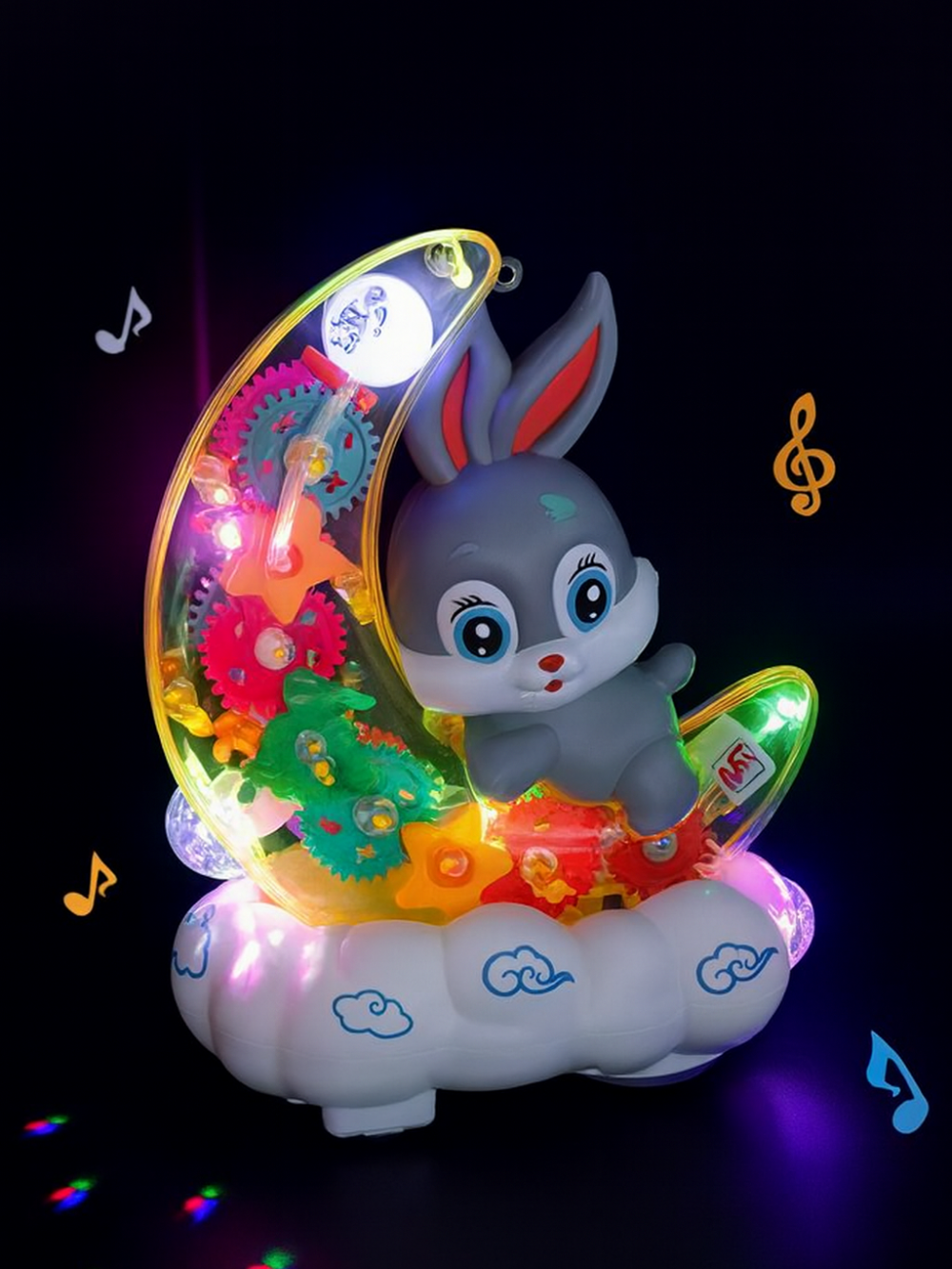 暗い背景に、雲の形の台座に乗った三日月とグレーのウサギが鮮やかなLEDで光るミュージックトイ。カラフルな歯車と星型パーツが輝き、子ども向けのナイトライトおもちゃの雰囲気を出している。
