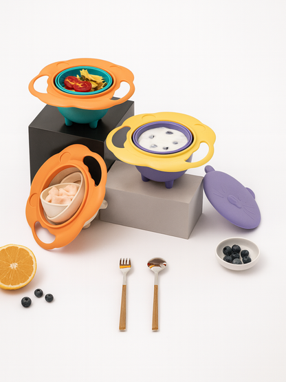 3色の360度回転ジャイロボウルとフタをブロックの上に並べ フォーク・スプーンとフルーツを添えたテーブルコーディネート画像（こぼれにくいスピルプルーフボウル）
