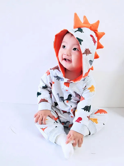 フード付き恐竜柄ベビー着ぐるみロンパースを着た赤ちゃんの正面ショット
