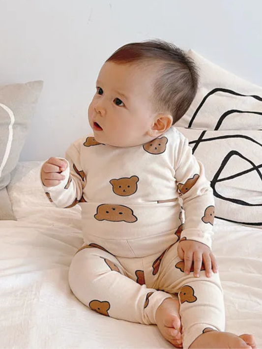 くま柄コットン長袖パジャマ上下セットを着てベッドに座るベビーの正面ショット
