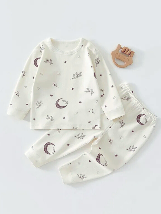 ホワイト地に月や星と小さな枝モチーフが総柄で描かれた長袖トップスとロングパンツのベビーパジャマ上下セット
