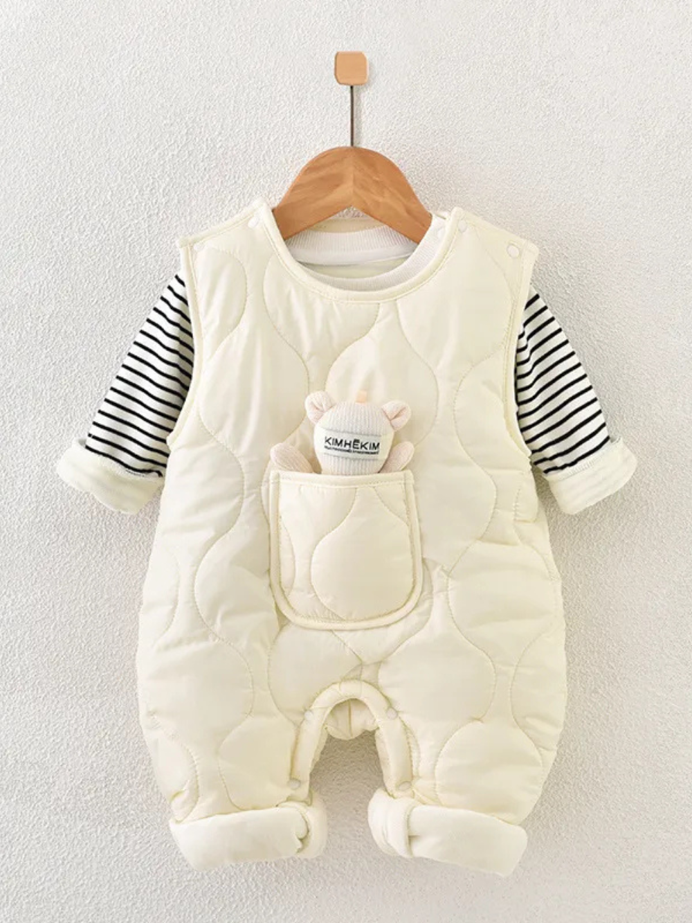 ボーダー長袖インナーとベージュの中綿ロンパースを重ねたベビーセットアップがハンガーに掛けられている画像
