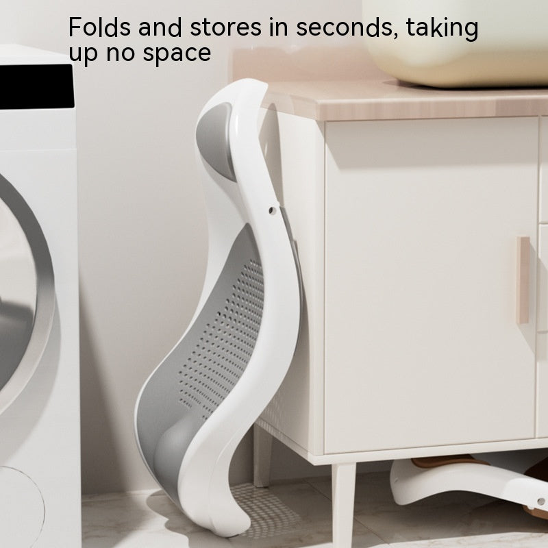 折りたたんだベビーバスチェアを洗面台横のキャビネットに立てかけて収納している様子を写した写真（省スペース収納できる折りたたみベビーバス）
