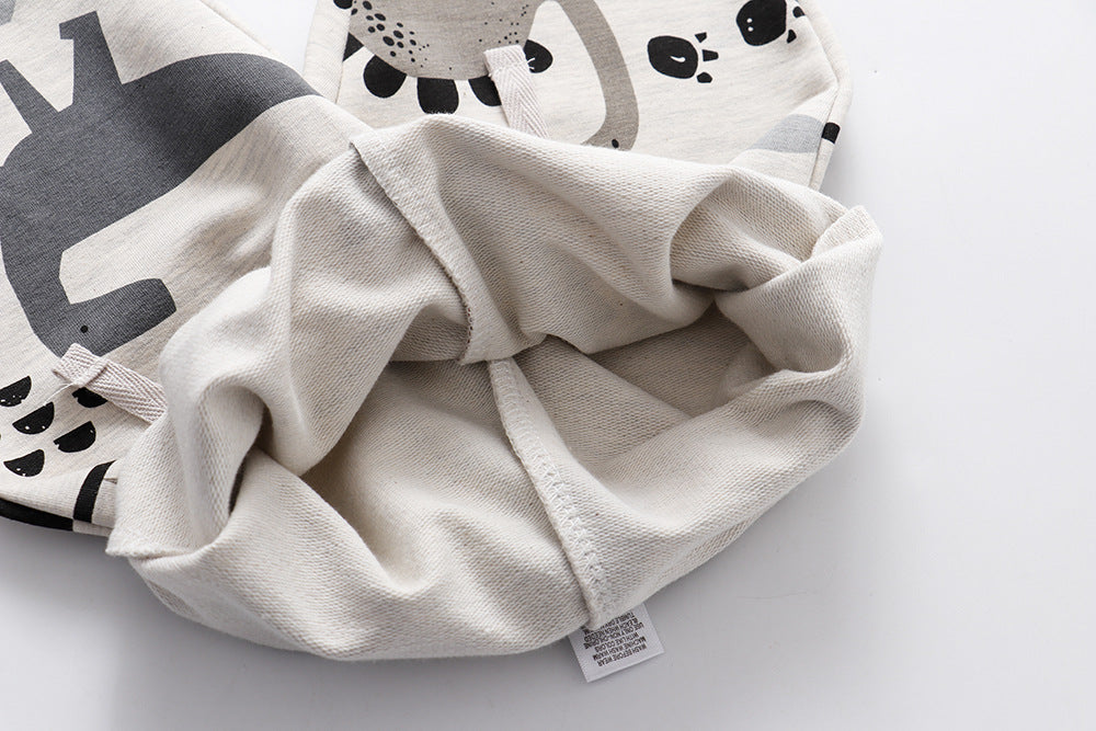 前面に大小さまざまな恐竜が描かれたスポーツパンツのプリントディテール
