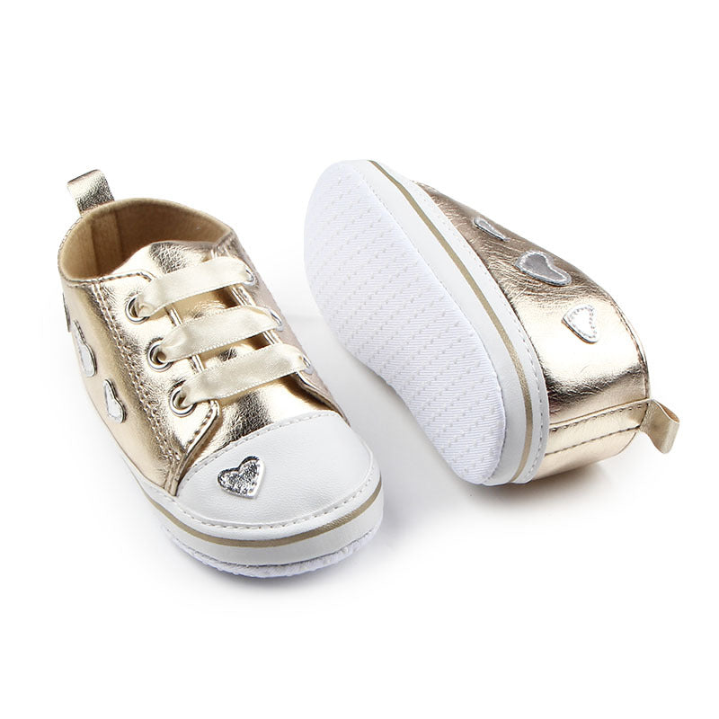 ゴールドのきらめきが映えるハートデザインベビーシューズのクローズアップ写真
