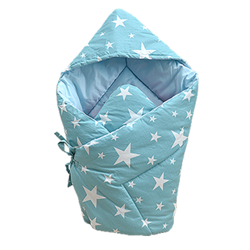 ブルーの王冠柄ベビーおくるみに赤ちゃんがくるまれている写真（ベビーおくるみ ブルー 王冠柄 純綿）
