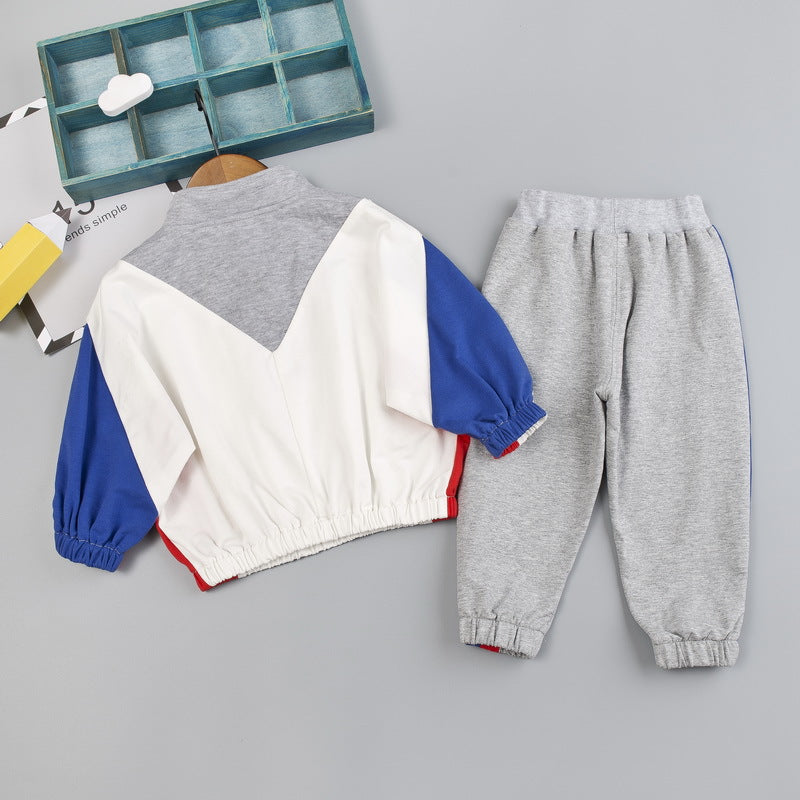 ブルーとレッド配色スリーブトップスとグレー長ズボンのキッズスポーツセットアップ後ろ姿
